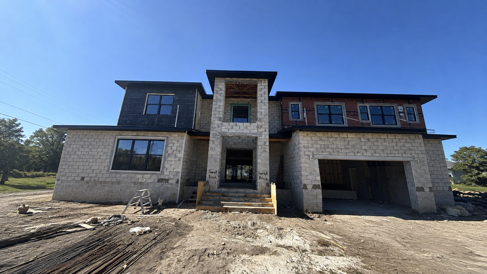 Home before stucco — bare block and framing