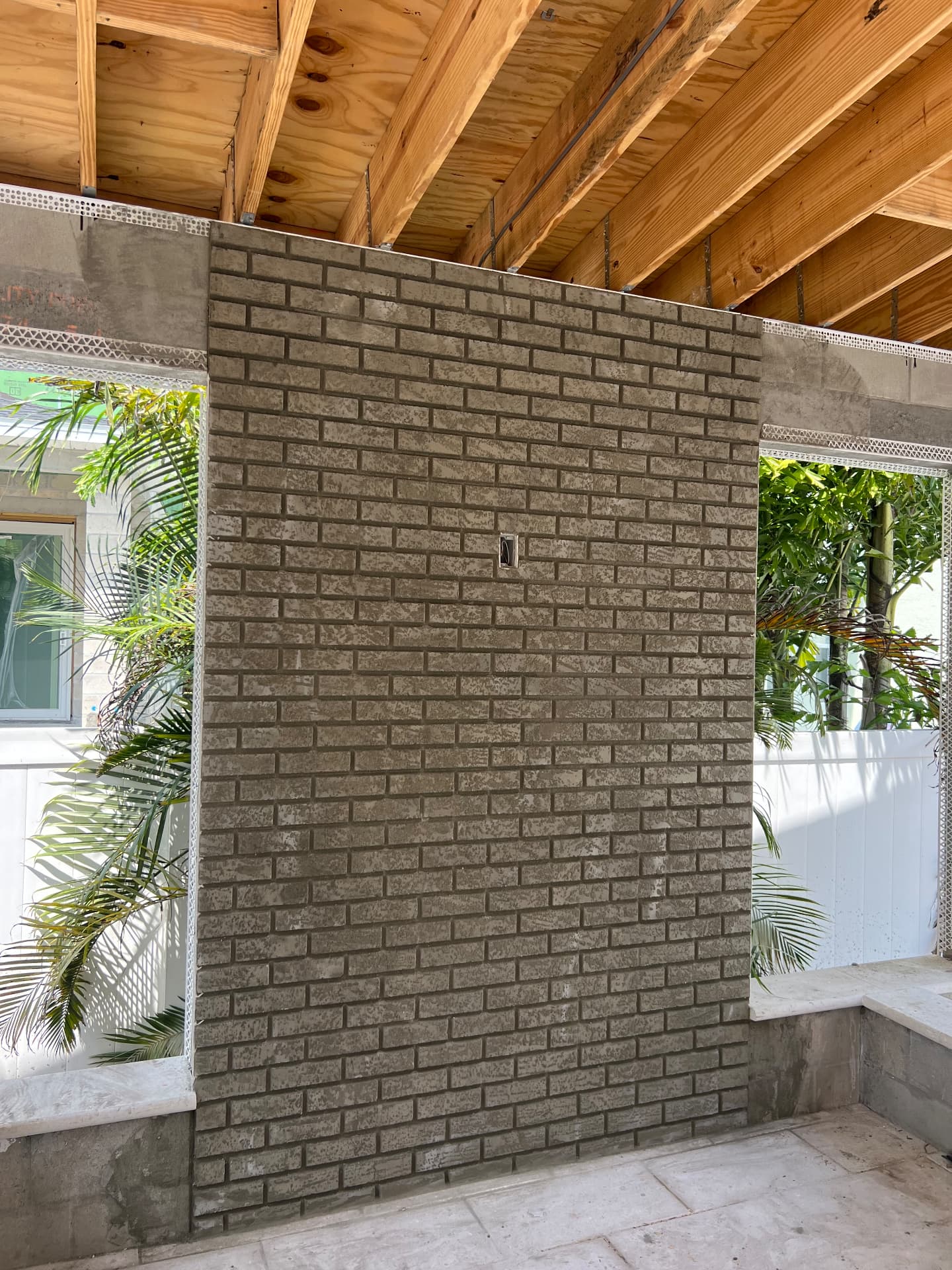 Outdoor patio accent wall with brick-pattern stucco texture