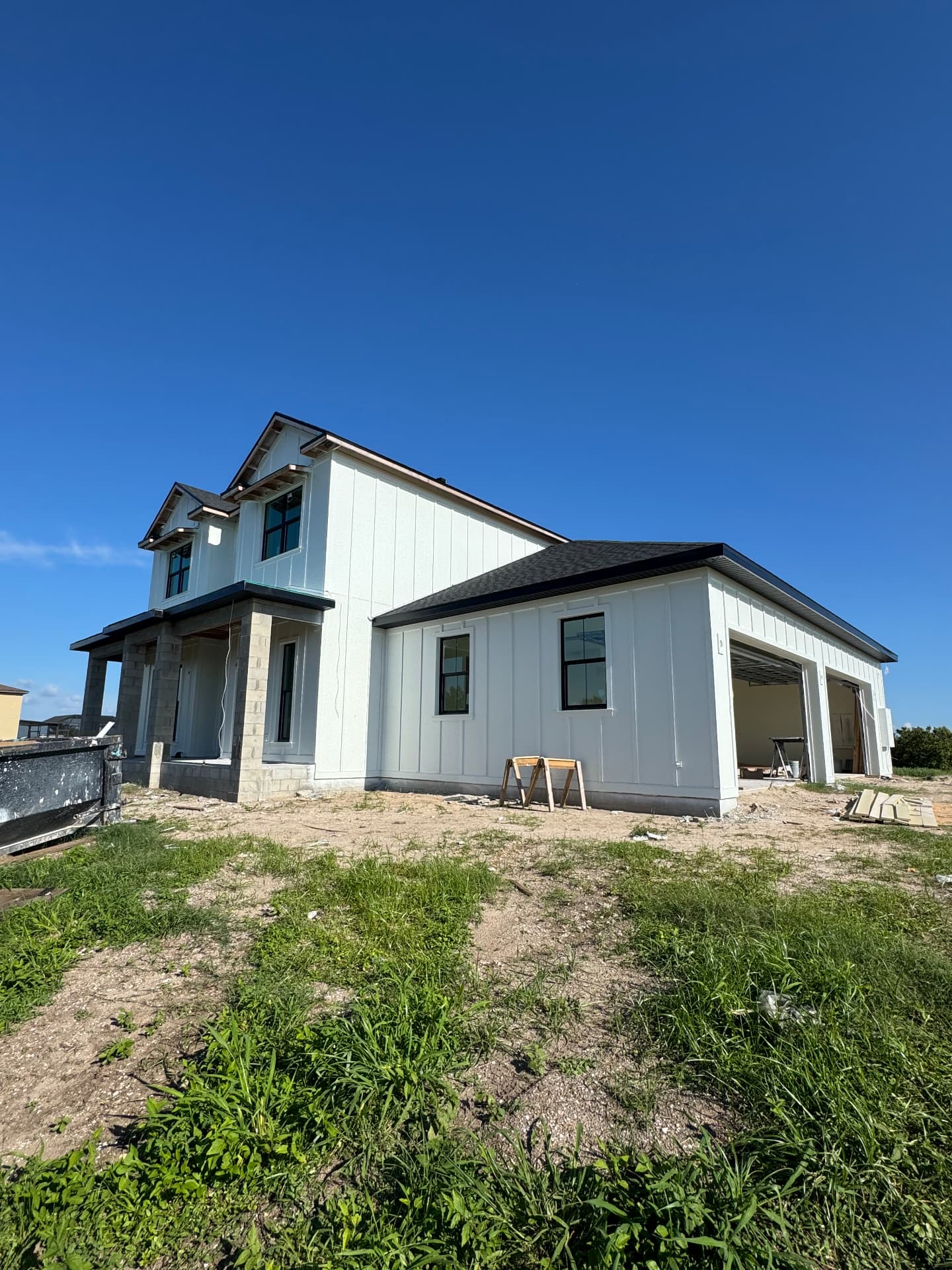 New construction farmhouse with board-and-batten and stucco columns