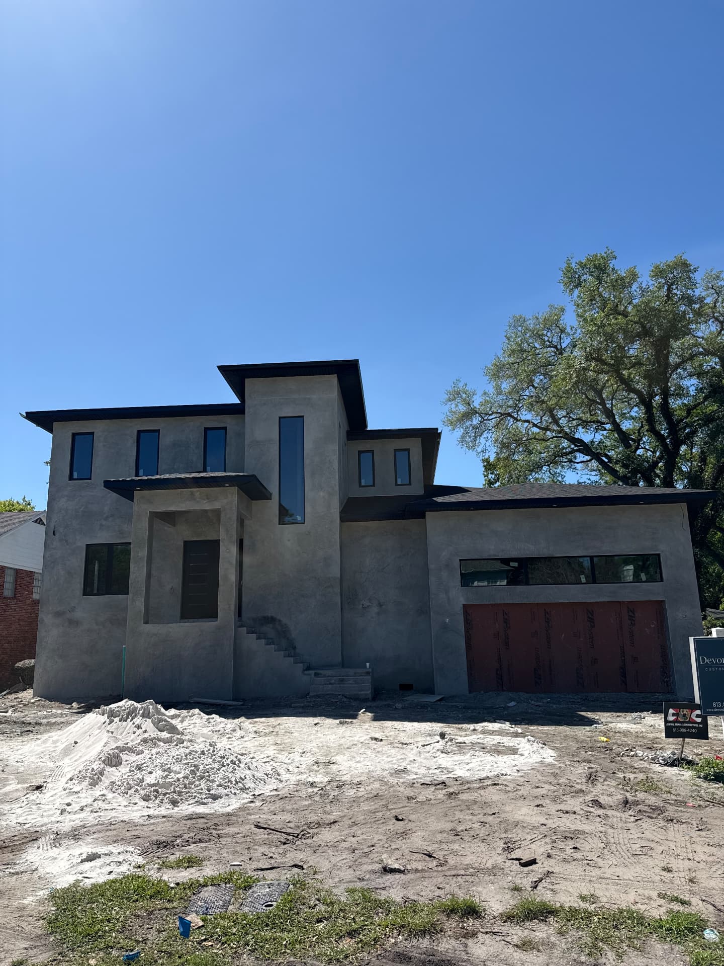 Custom home with fresh gray stucco exterior in progress